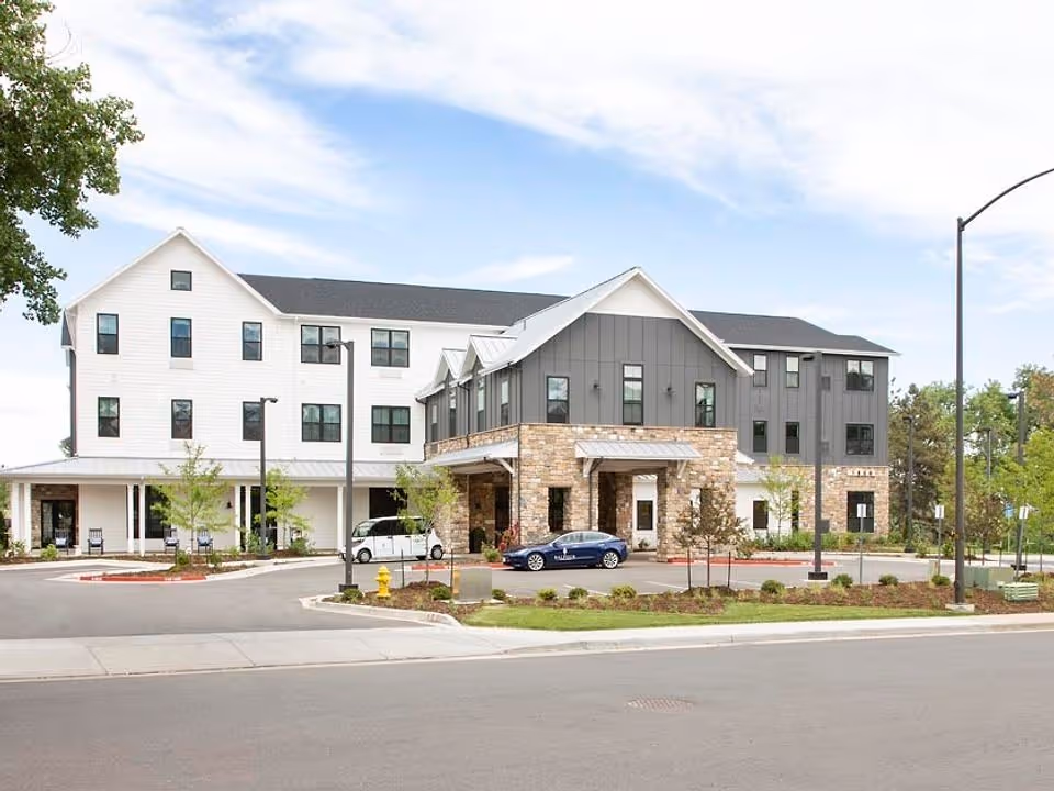 The Residences at Balfour exterior: modern multi-story building with stone entrance and driveway.