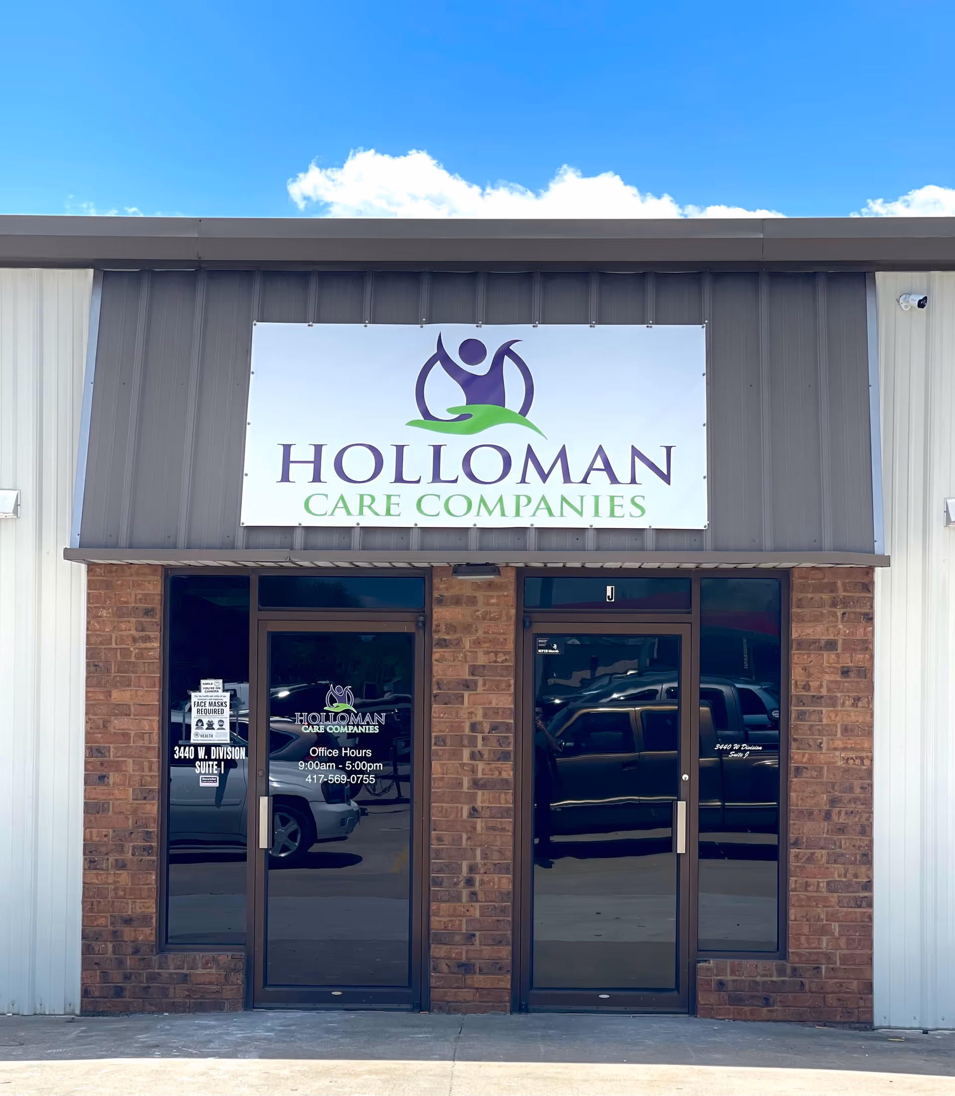 Front view of Holloman Care Companies building with brick entrance and large sign.