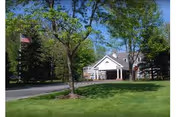 Exterior view of Greenwich Woods Rehabilitation building with trees and flag.