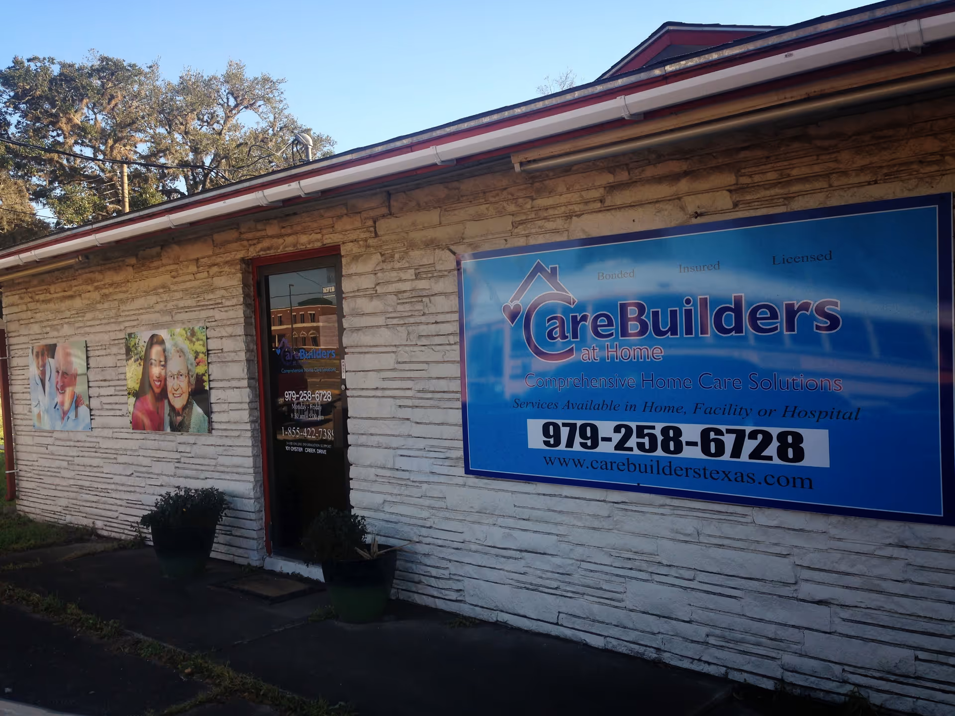 Exterior view of CareBuilders at Home facility with large blue sign and potted plants.