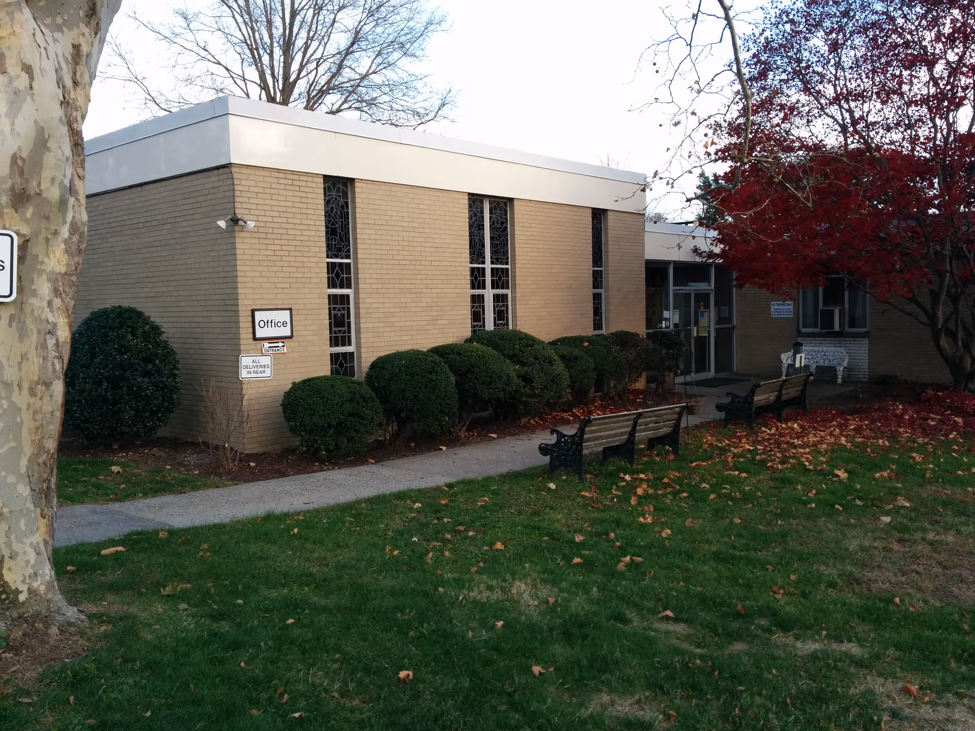 Exterior view of Notre Dame Health and Rehabilitation Center with benches along a walkway.