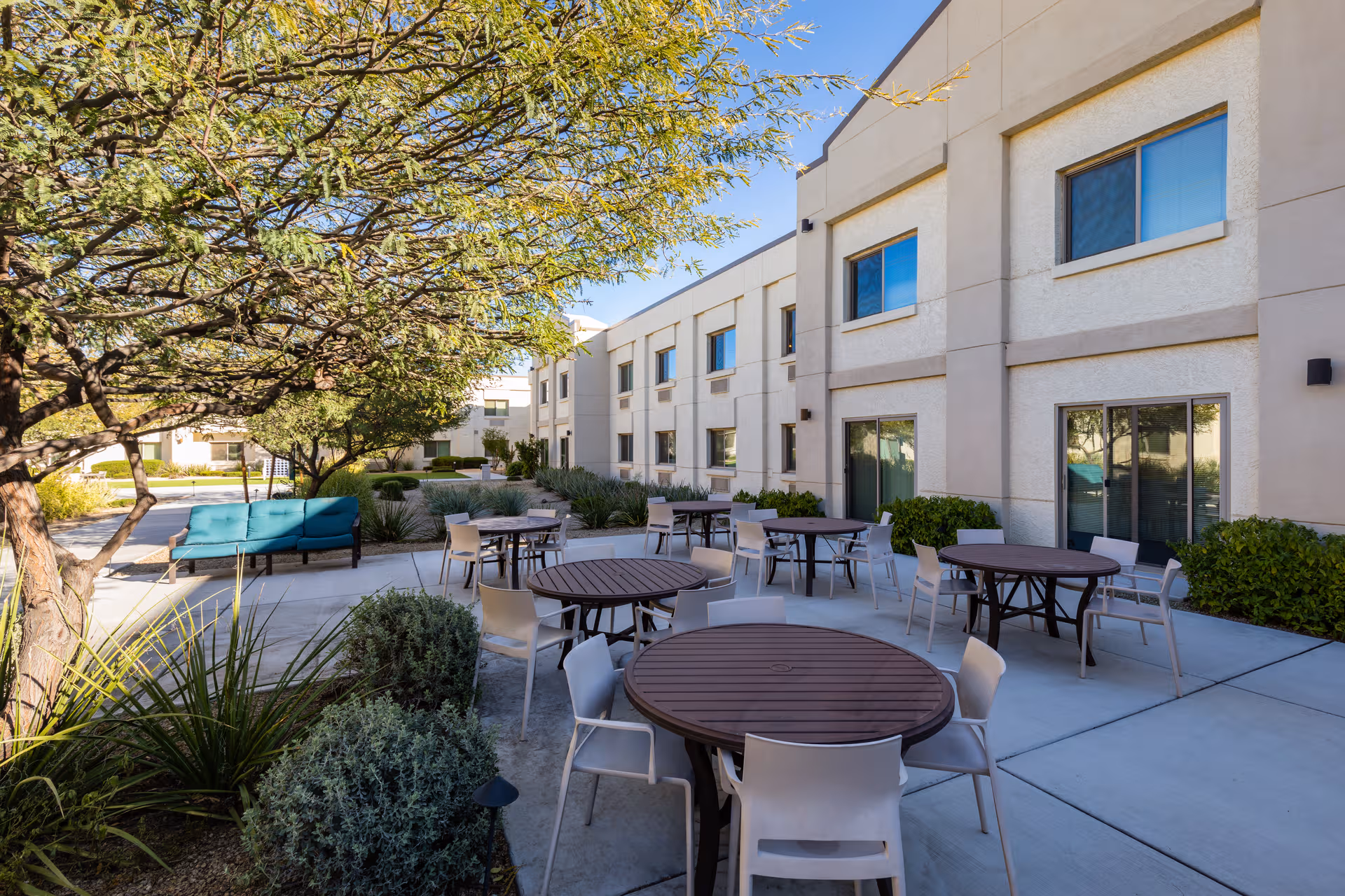 Outdoor courtyard at BridgeWater Assisted Living - Deer Valley with round tables and chairs