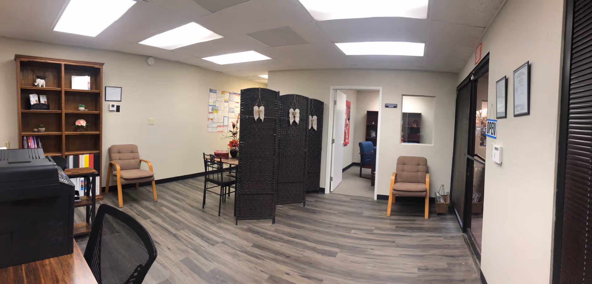 Spacious interior lobby with seating, bookshelf, and a privacy screen.