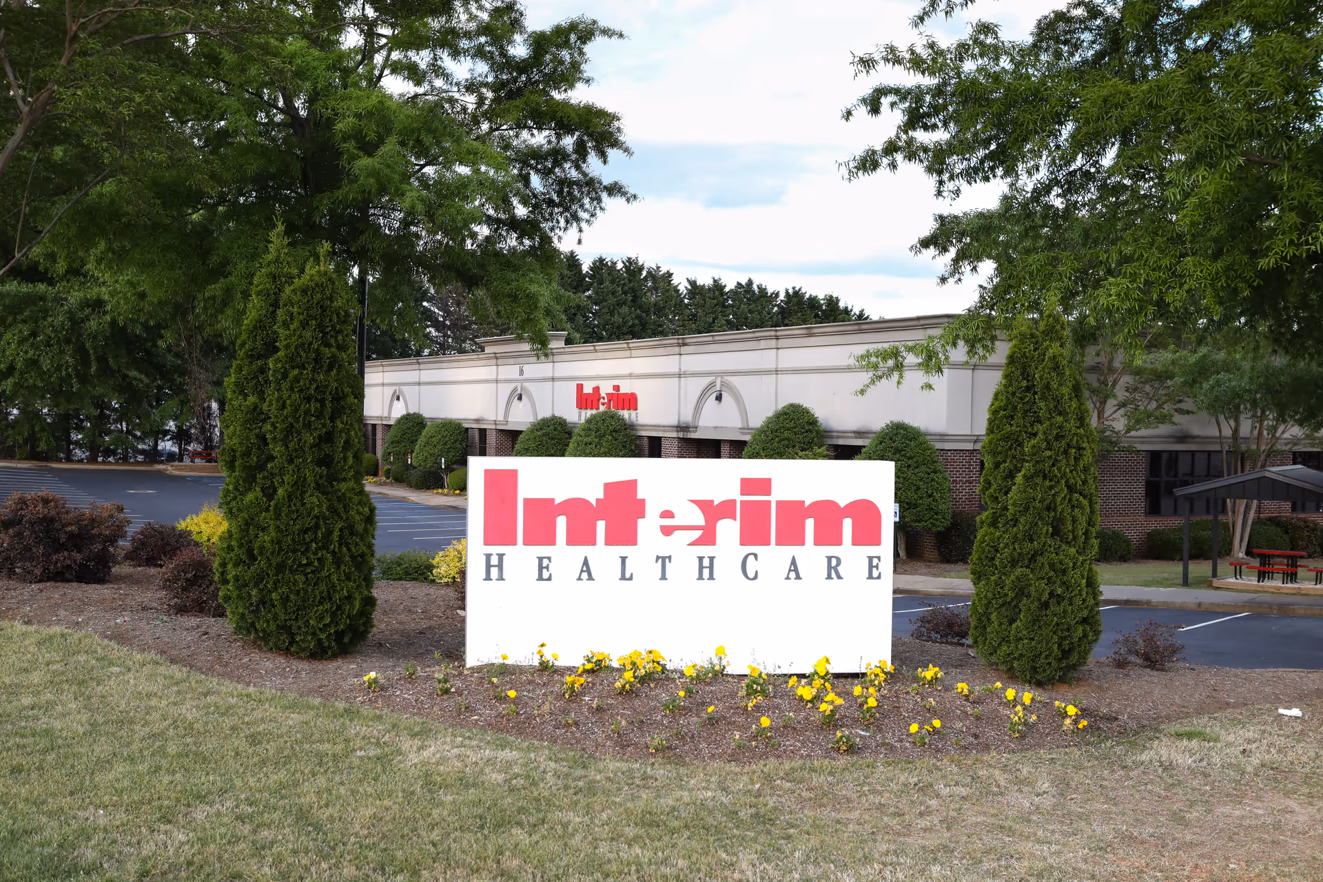 Exterior view of Interim HealthCare building with a large front sign and landscaping.