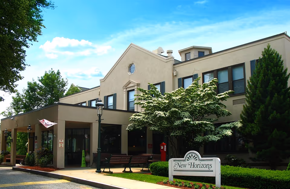 Exterior view of New Horizons at Choate with building facade, trees, benches, and sign