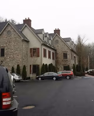 Exterior view of a senior living facility with stone and beige siding.