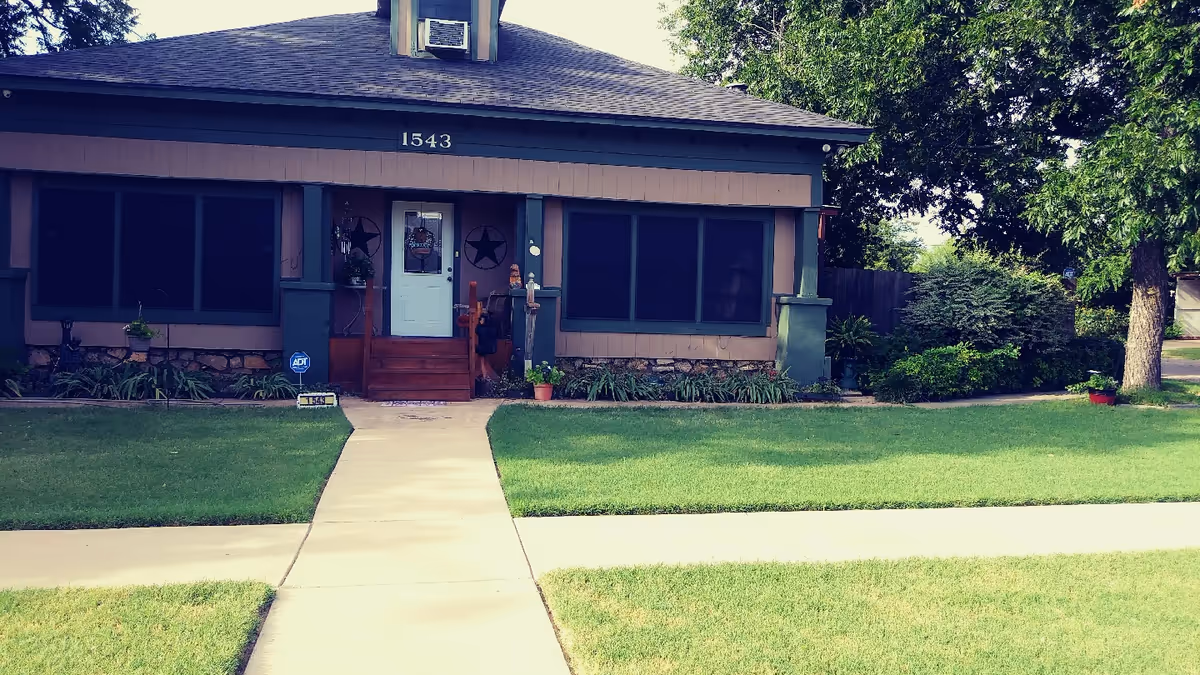 Front exterior of a single-story assisted living home with walkway and well-kept lawn