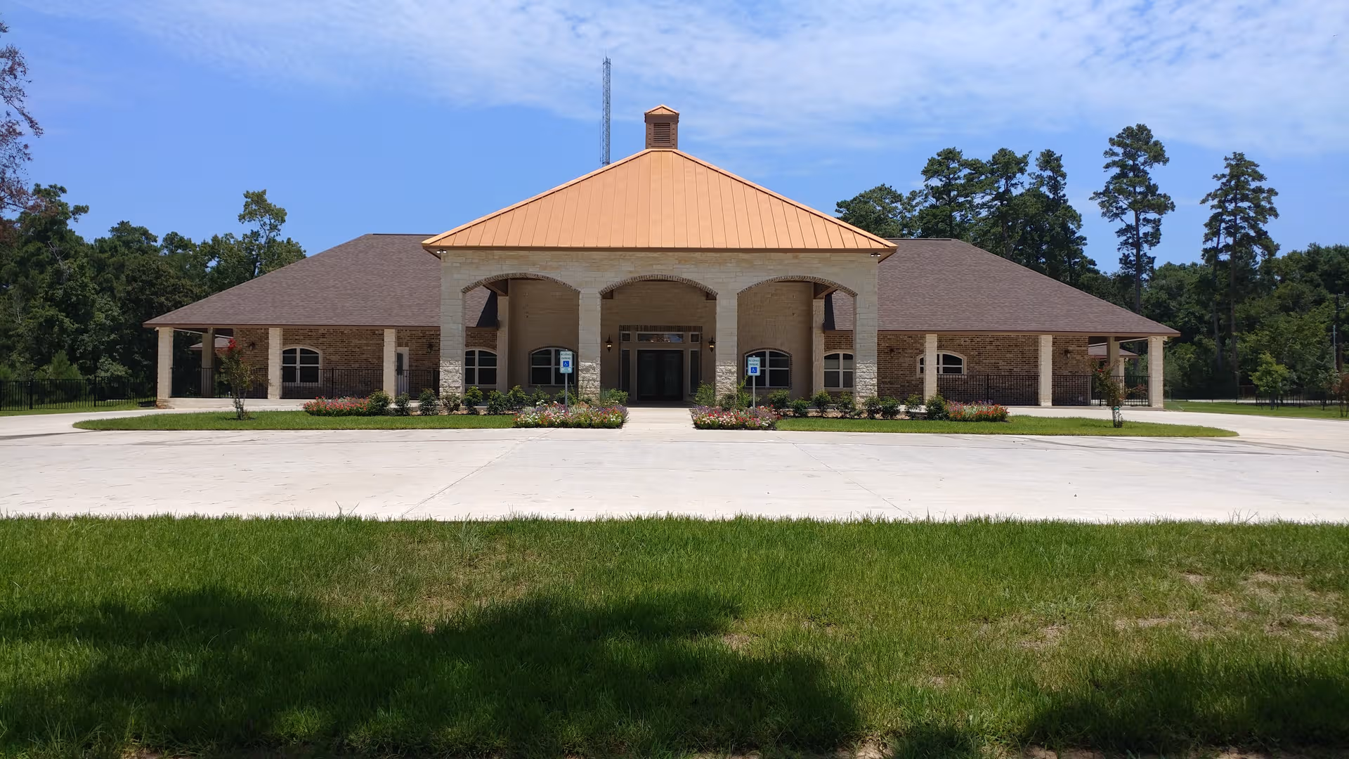Front view of a single-story senior care facility with a covered entrance and landscaped driveway.