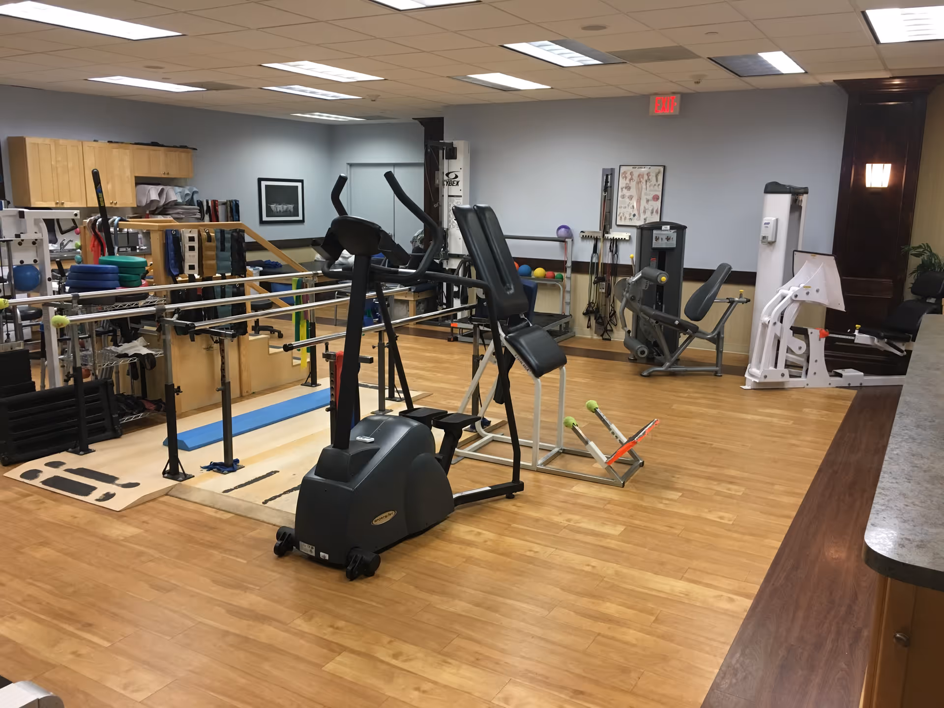 AgeWell rehabilitation gym with cardio and strength equipment inside a spacious, well-lit interior.
