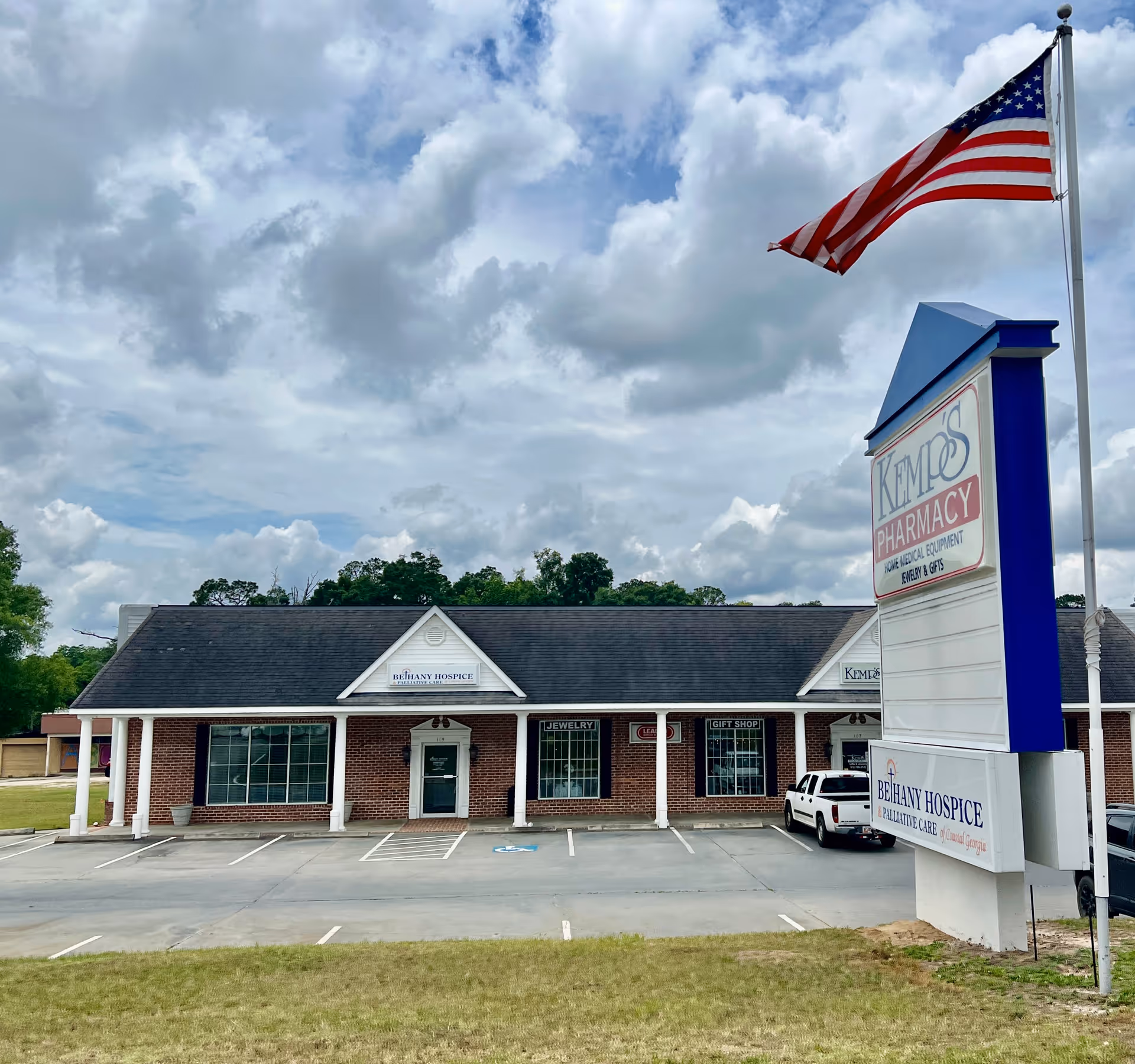 Exterior view of Bethany Hospice building with American flag and signage.