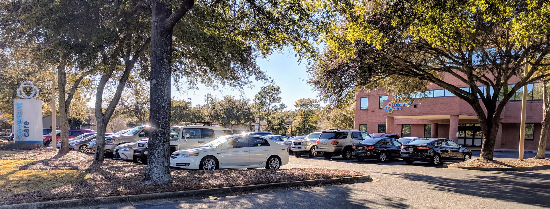 Exterior view of Covenant Care Home Health Care building with a parking lot and trees.