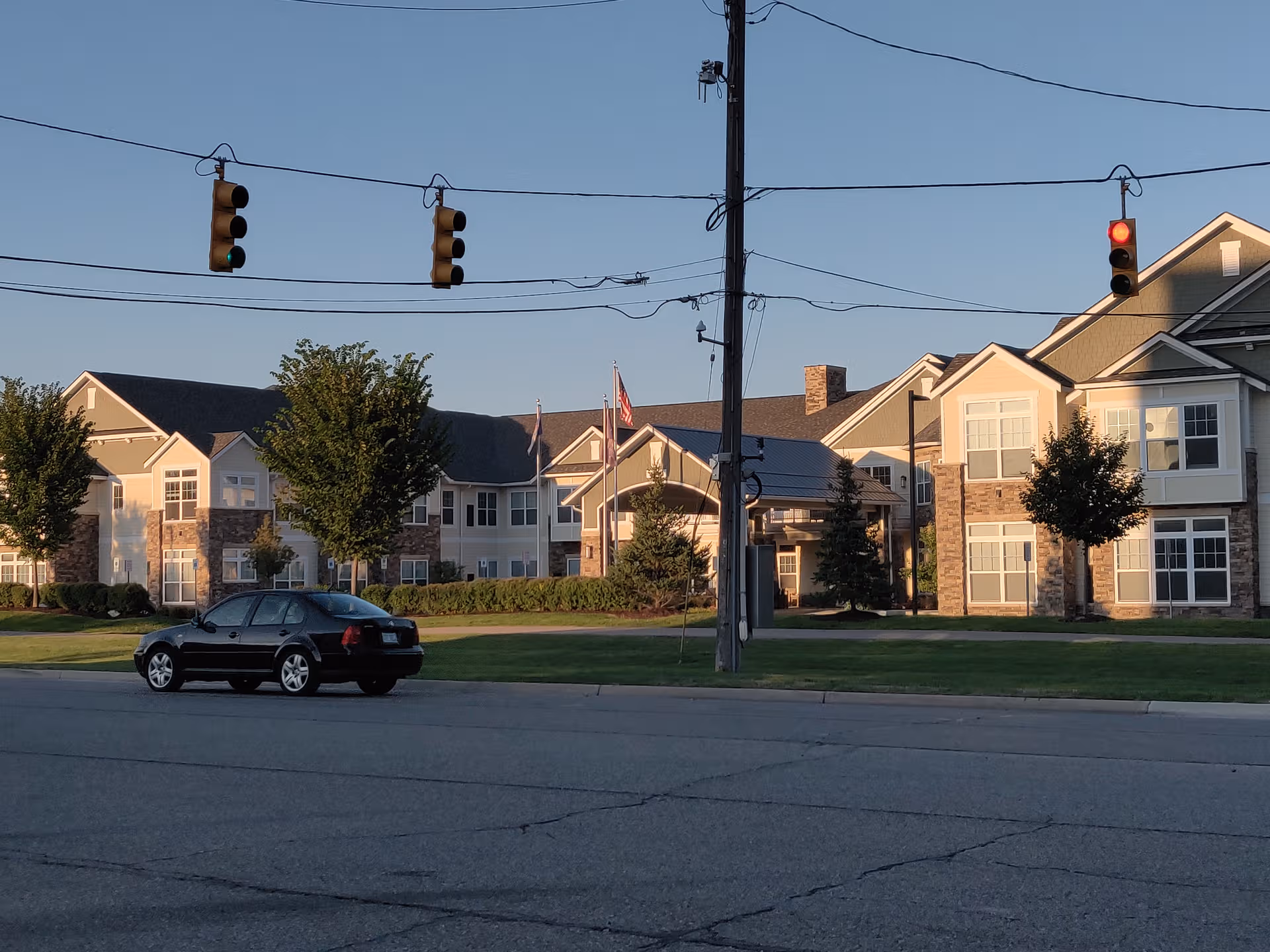 Exterior view of American House Somerset, a senior living campus with buildings, trees, and a street.