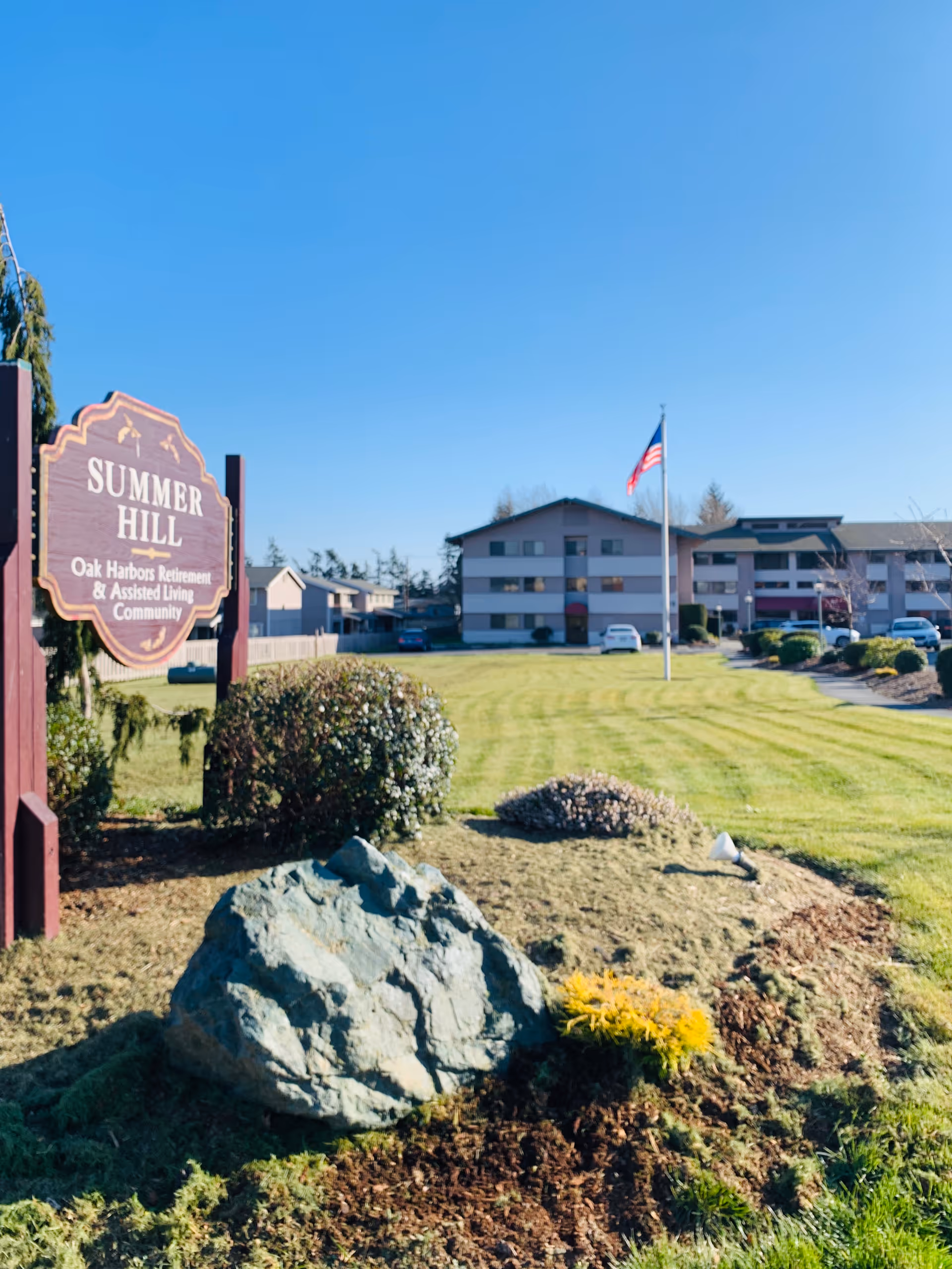 Exterior view of Summer Hill sign with lawn and American flag.