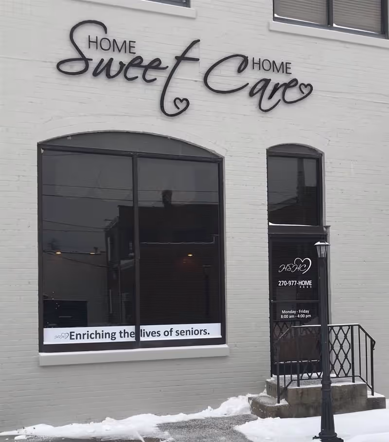 Exterior of a building with Home Sweet Home Care sign and large glass windows.