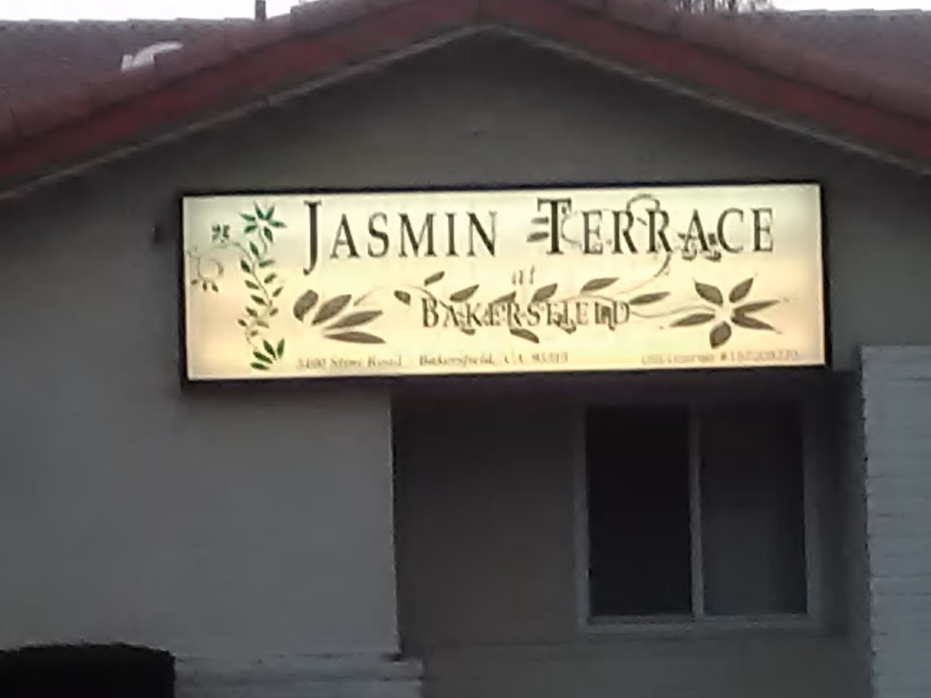 Exterior of a building with a Jasmin Terrace sign and window.