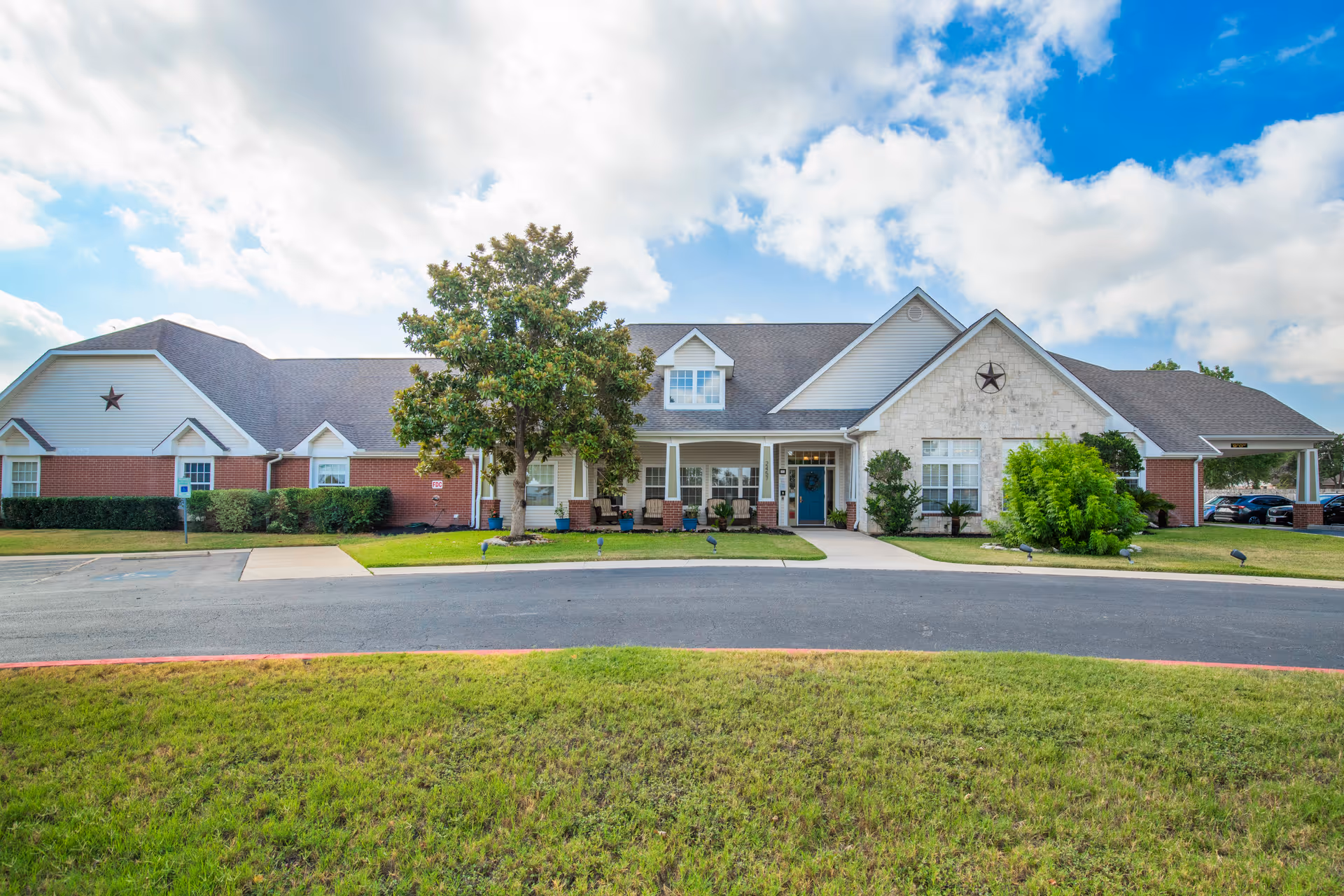 Exterior view of Brookdale New Braunfels facility with manicured lawn and driveway.