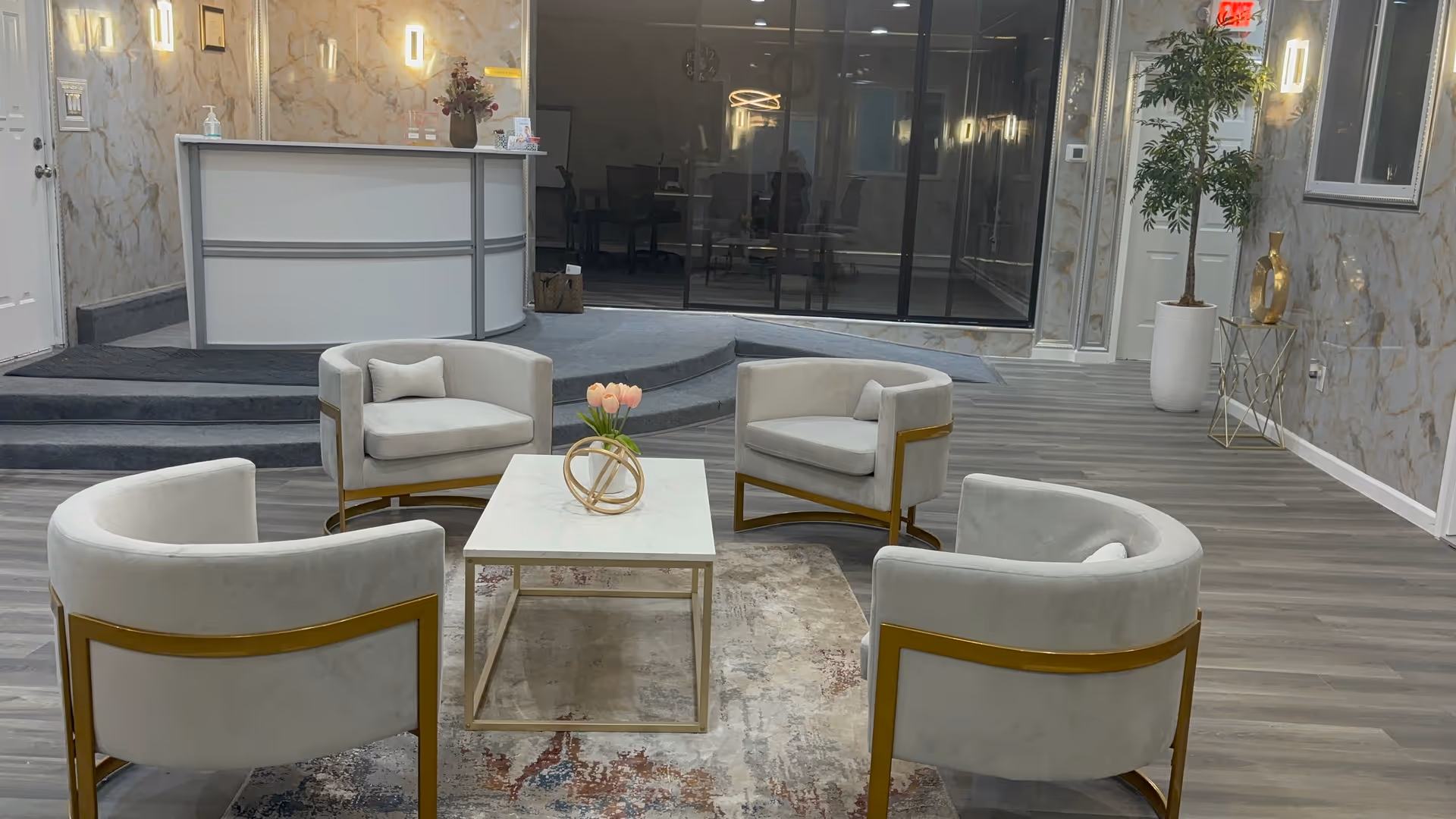 Modern lobby with circular chairs around a coffee table in marble-walled reception area.
