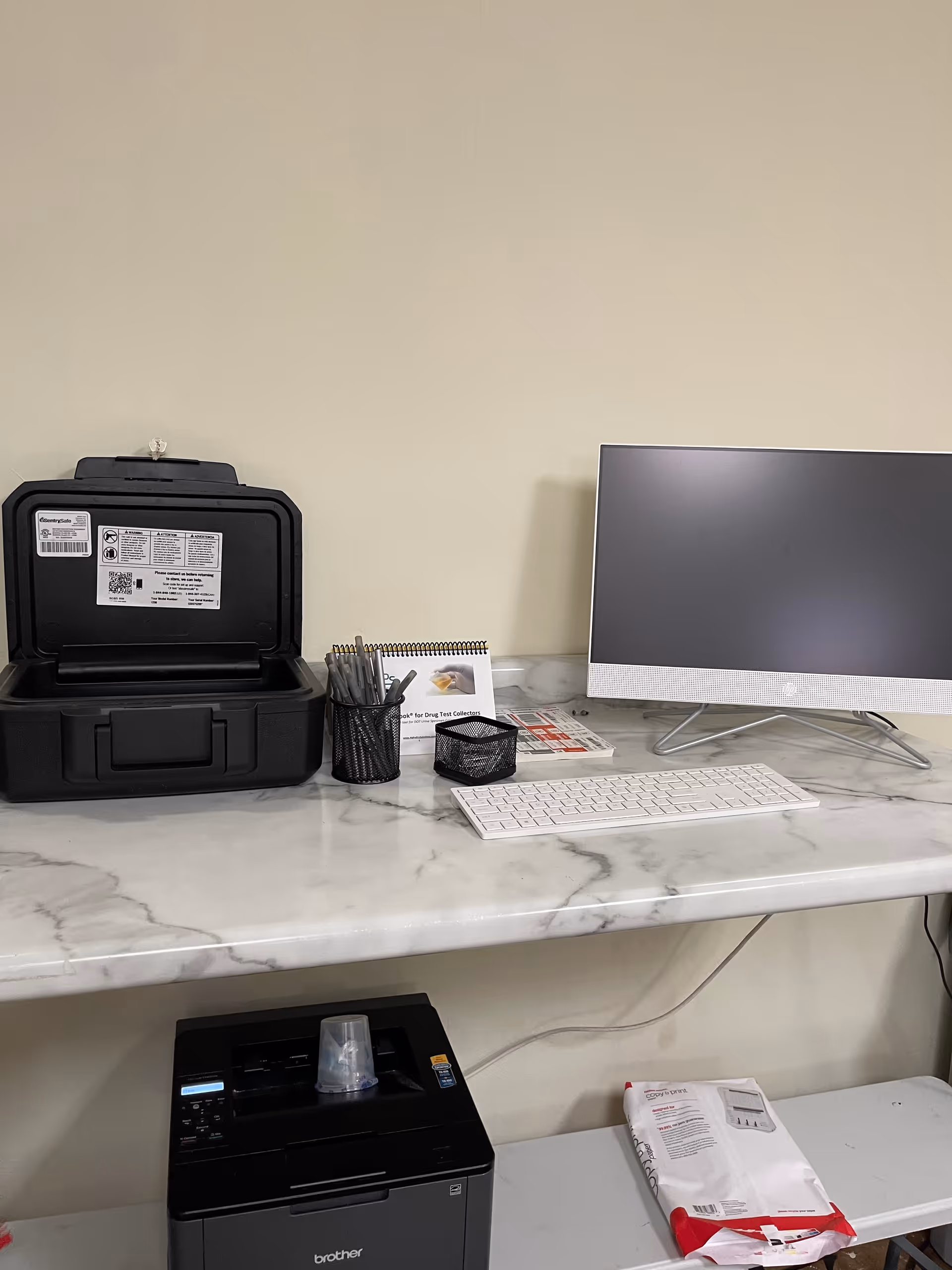 Marble desk with computer monitor, calendar, and printer in an office workspace.