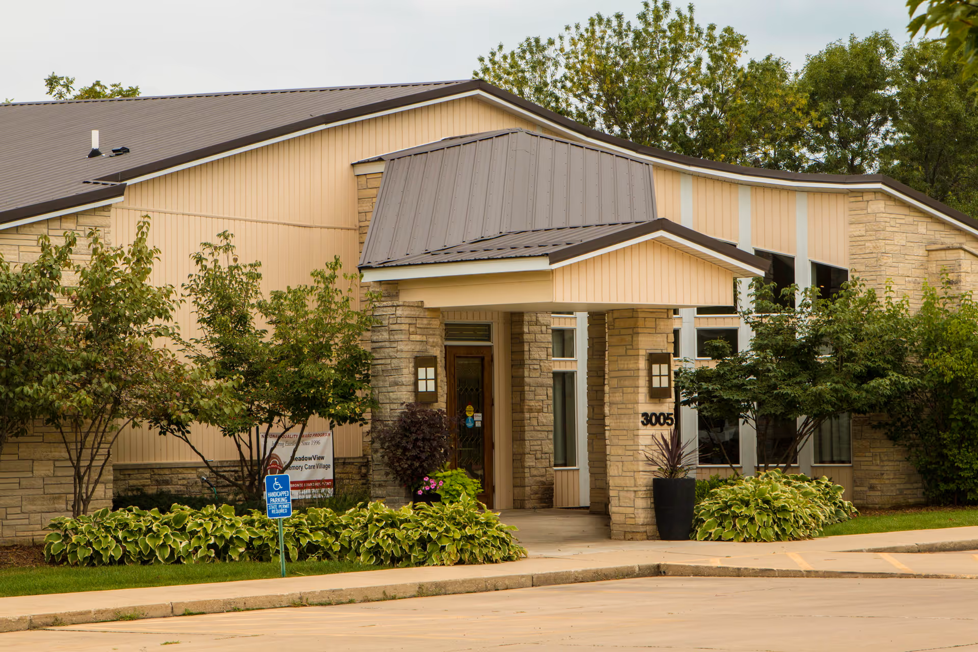 Front entrance of The Views of Cedar Rapids, a beige-brick senior living facility.