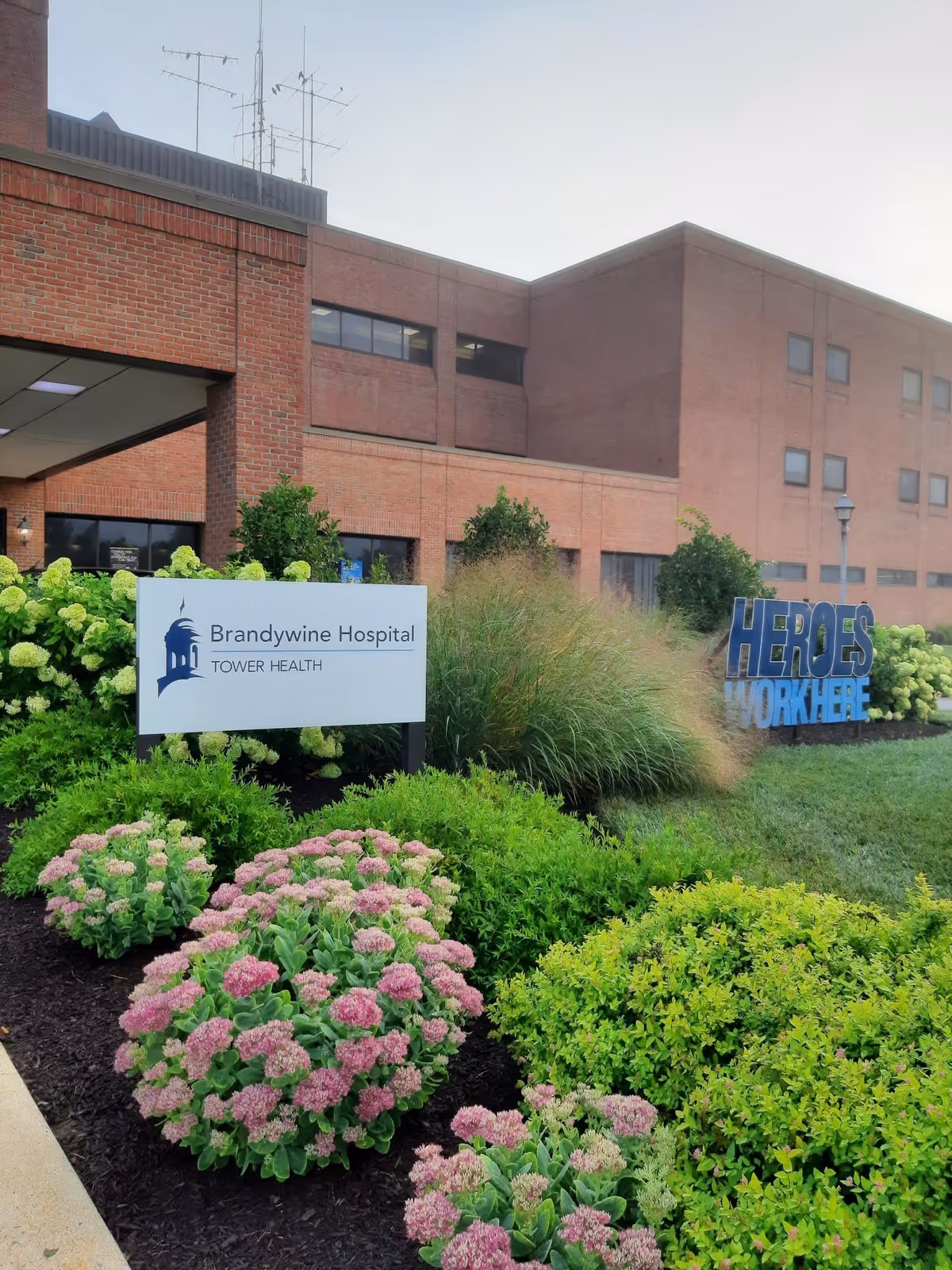 Brick building exterior with Brandywine Hospital sign and landscaped front garden.