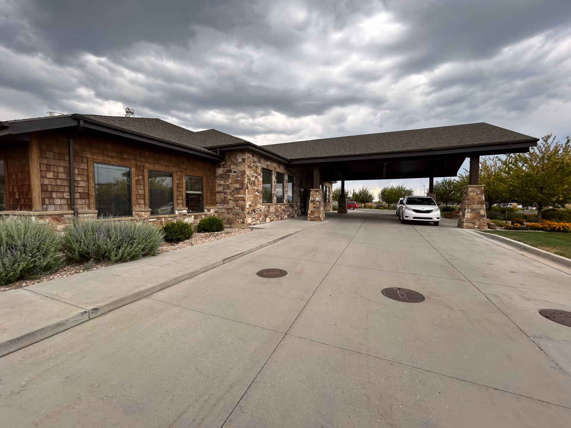Stonehenge of Springville exterior with stone facade and a covered entrance drive.