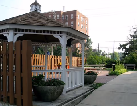Outdoor gazebo with white railings and planters in Luther Towers II courtyard.