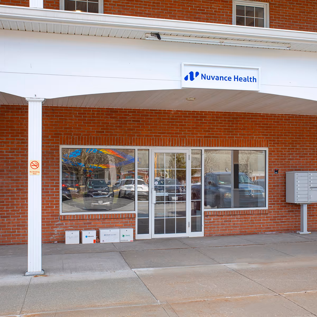 Brick storefront with glass doors and a Nuvance Health sign.