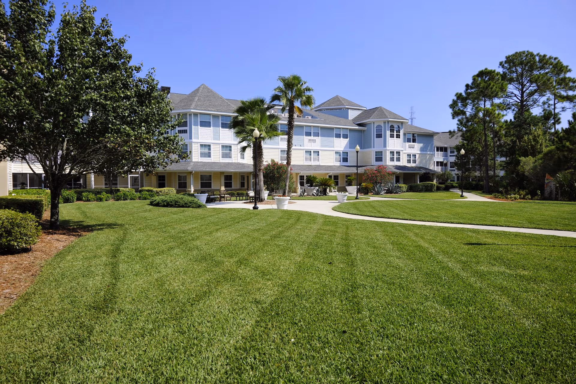 Front view of Allegro Senior Living in St. Augustine, FL, with a manicured lawn and walkway.