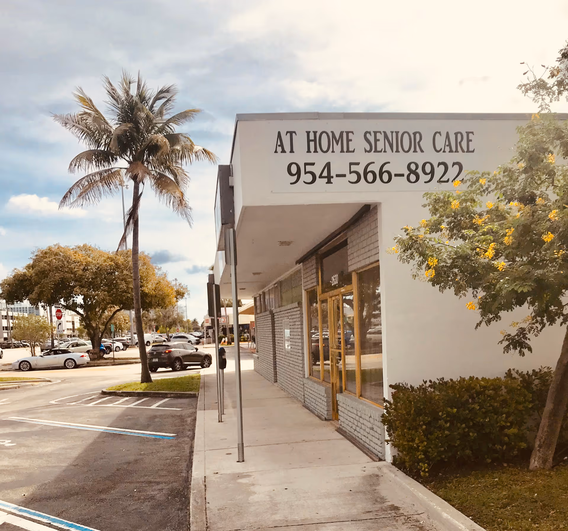Exterior view of a storefront senior care facility with sign 'At Home Senior Care'.