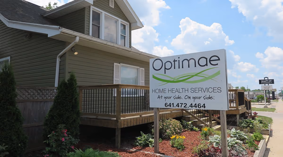 Exterior of Optimae Home Health Services building with a wooden deck and sign