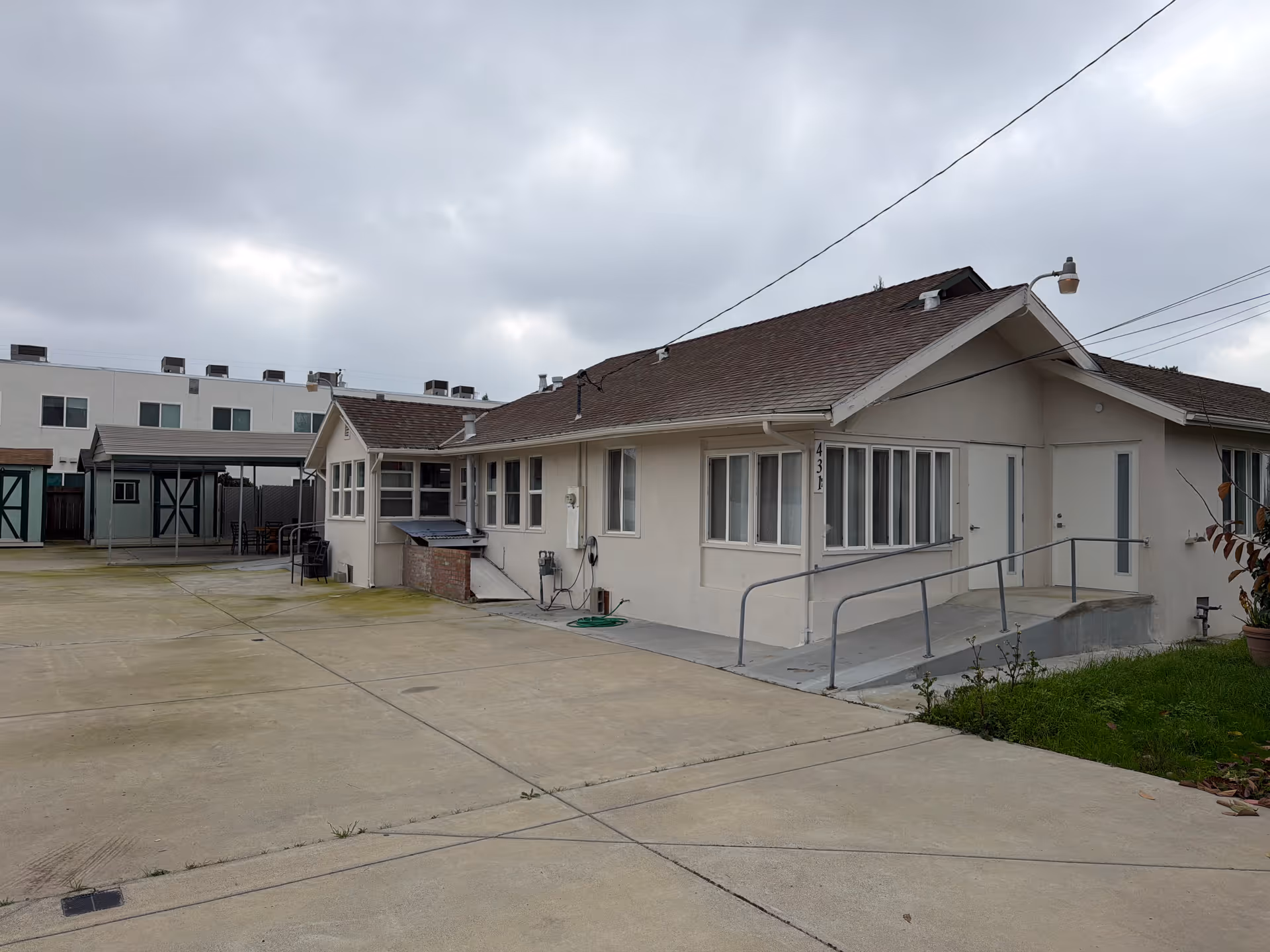 Exterior view of a single-story senior care facility with ramp and paved driveway