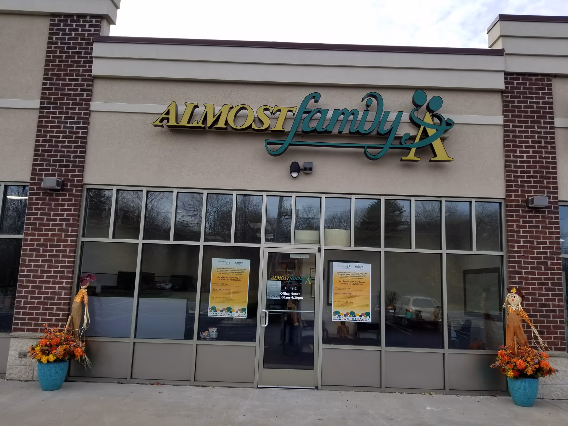 Exterior view of Almost Family senior living facility with glass entry doors and sign.