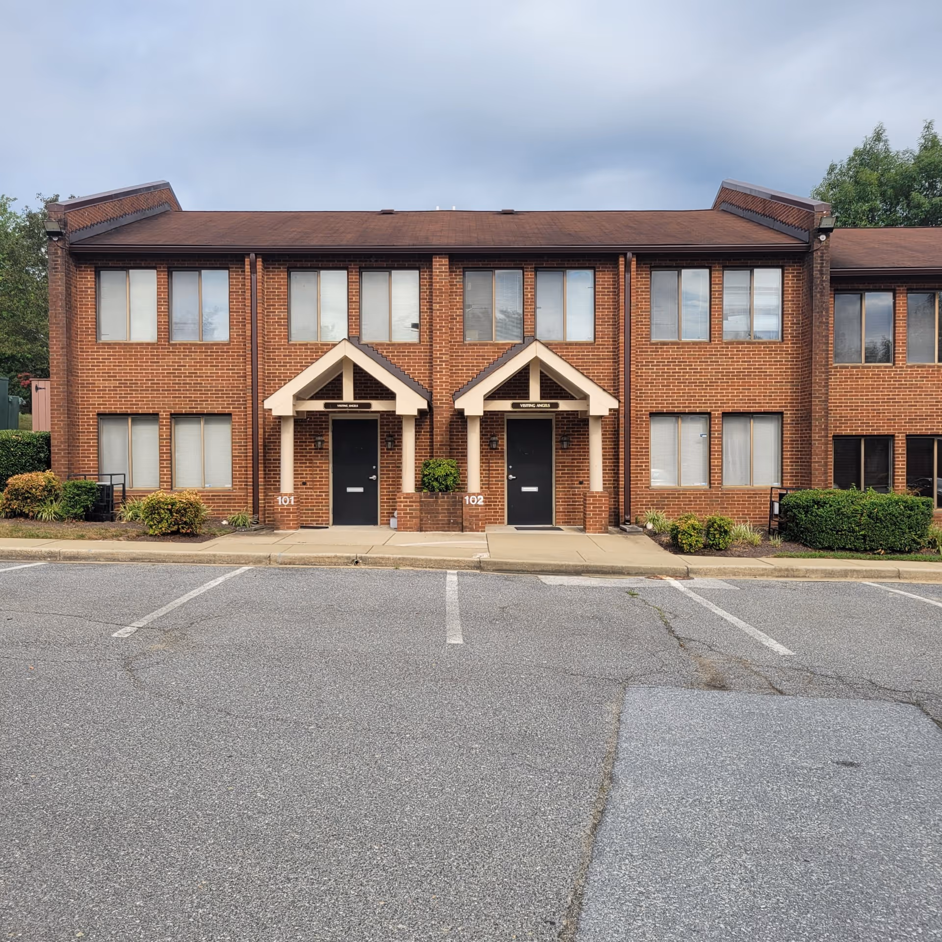 Two-story brick building with two front doors under gabled entrances.