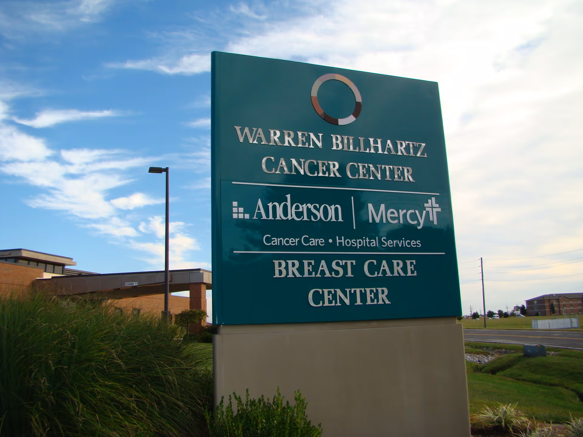 Large teal sign outside Anderson Hospital advertising cancer and breast care centers.
