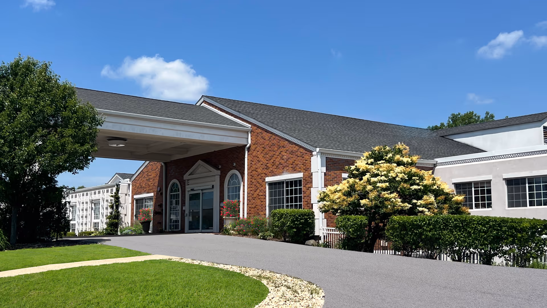 Brick exterior of Avantara Long Grove with a covered entrance and landscaped driveway.