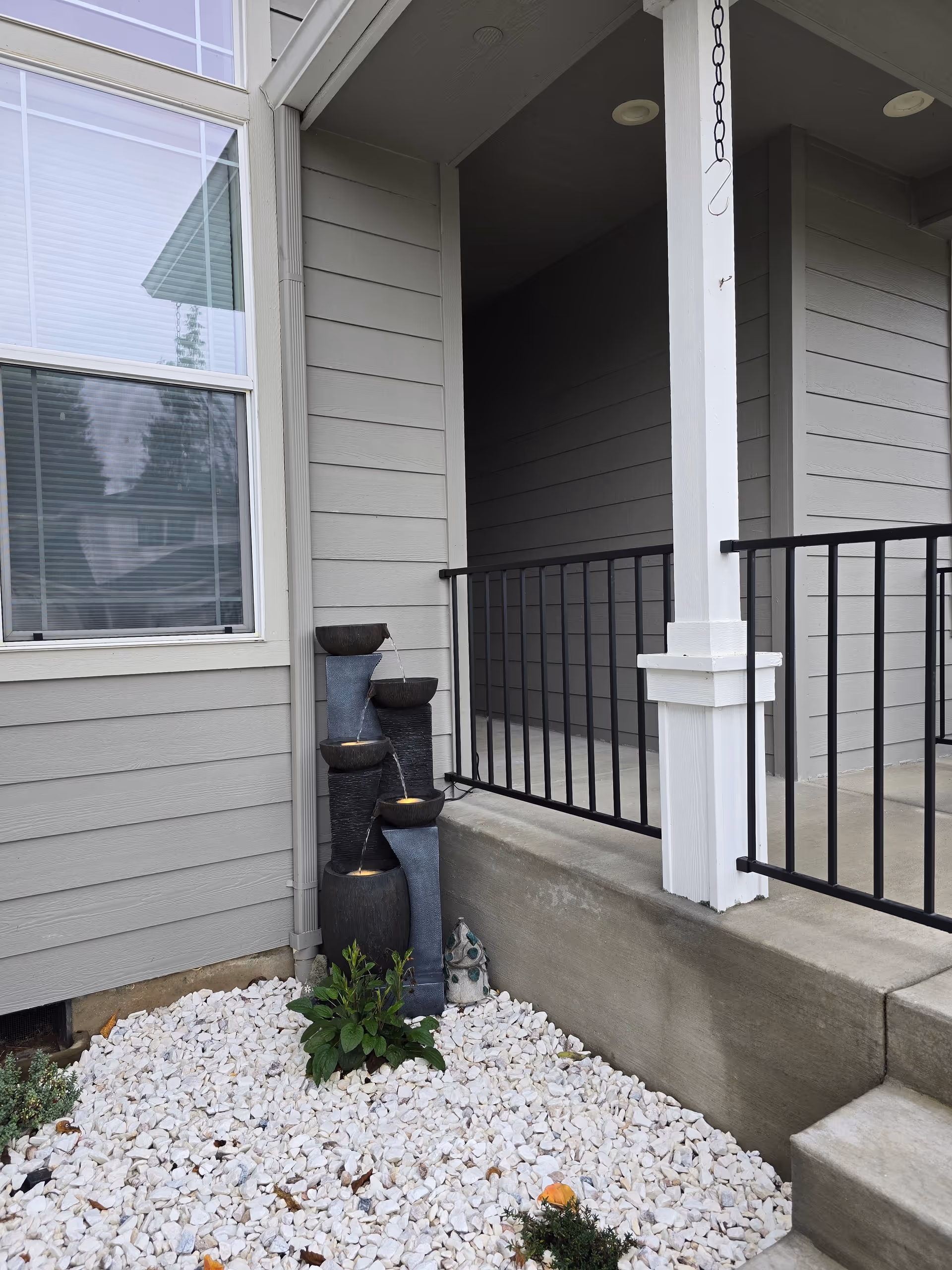 Sunquest Care Home exterior entrance with porch railing and a tiered water feature.