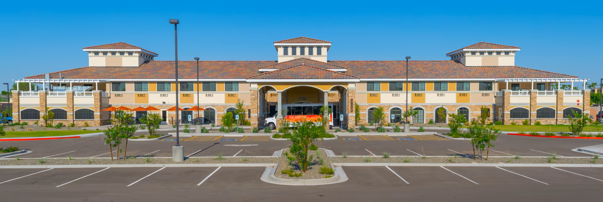Exterior view of The Mission at Agua Fria Senior Living building with parking.