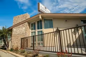 Exterior view of Lomita Post-Acute Care Center with railing, stone accents, and sign.