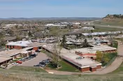 Aerial view of Aspen Grove Assisted Living campus with brick buildings and parking lots.