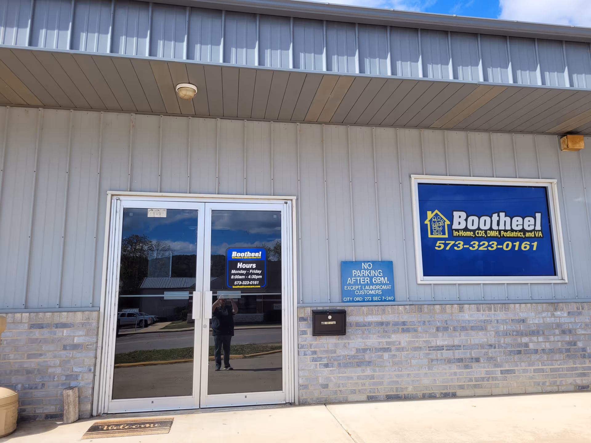 Exterior view of a gray building with a blue Bootheel sign and glass entrance.