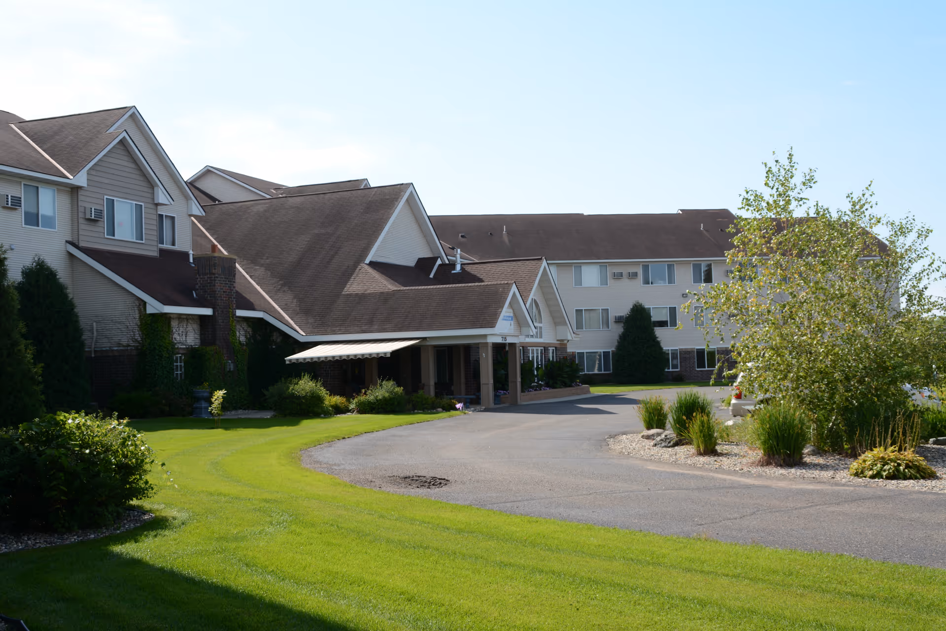 Exterior view of Vista Prairie at Windmill Ponds with entrance, circular drive, and landscaped grounds.