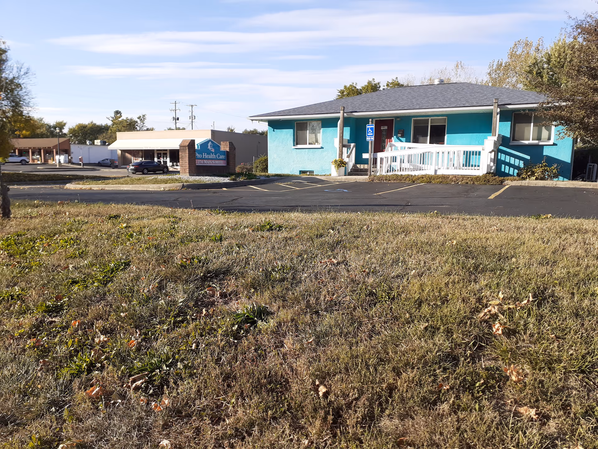 Exterior view of Pro Health Care Services building with turquoise facade and parking lot.