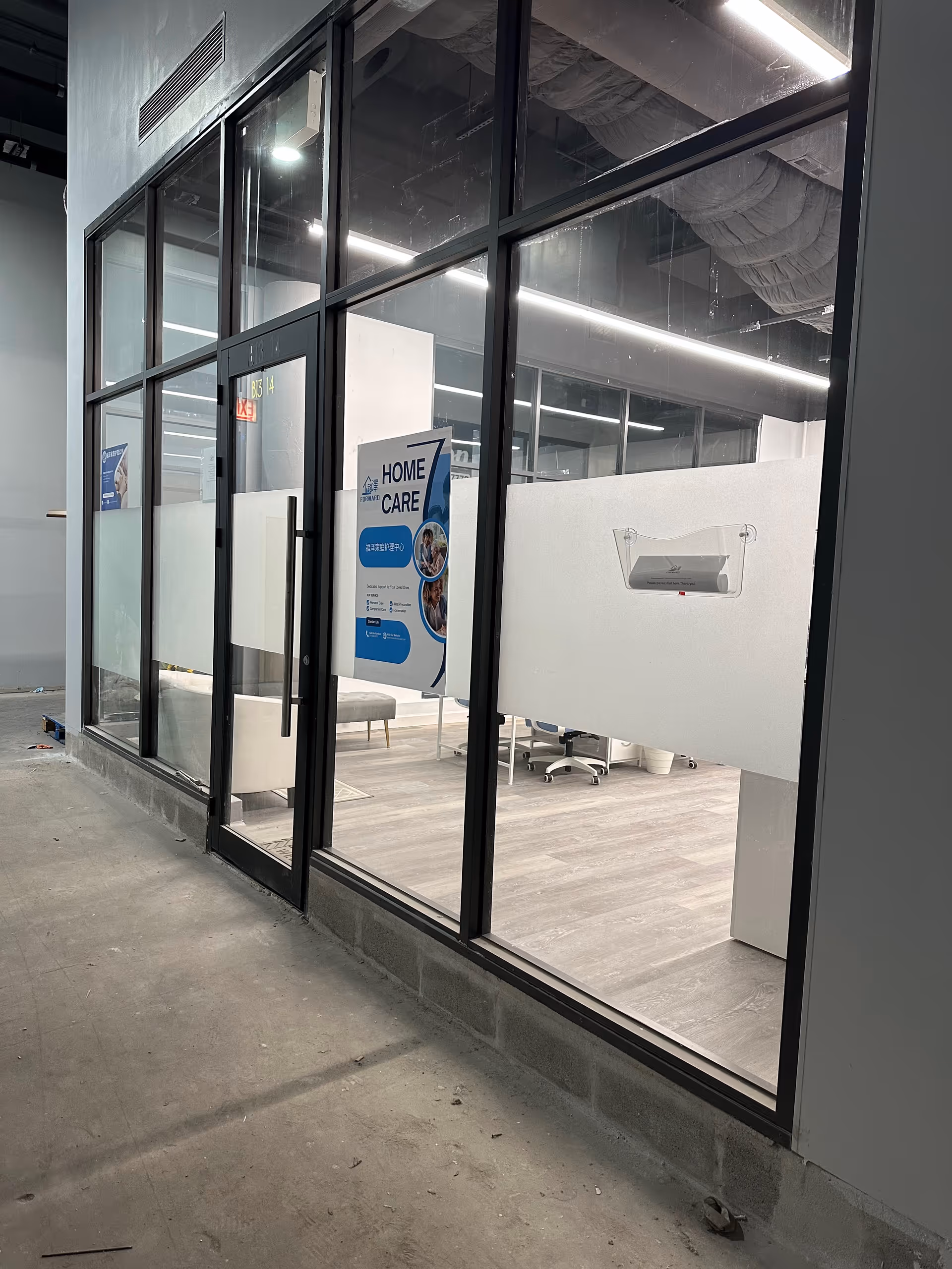 Glass-walled interior with a Forward Homecare sign and office furnishings.