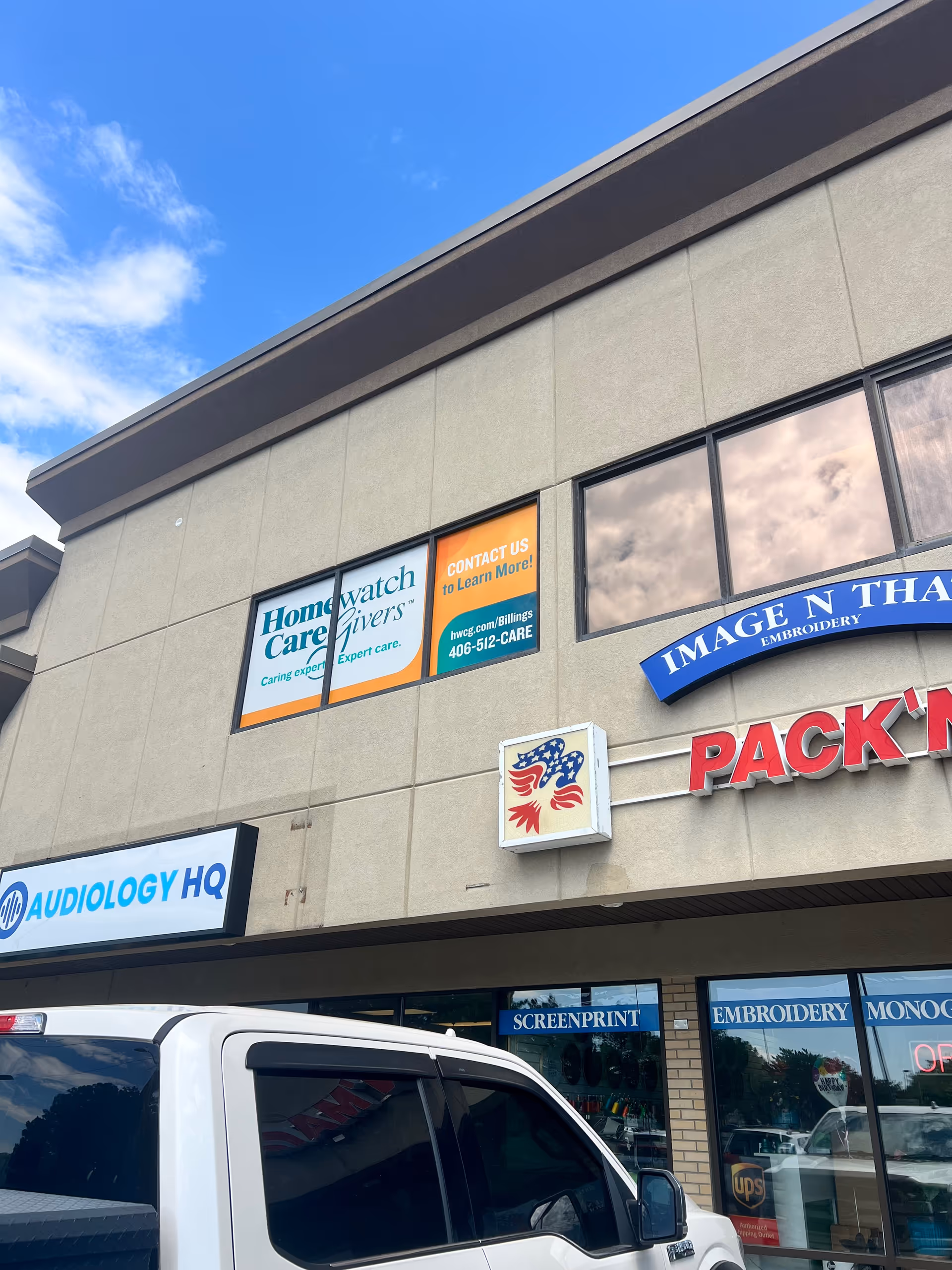 Exterior view of a strip mall with Homewatch CareGivers signage.