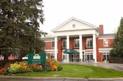 Front view of Westminster Village North brick building with white columns and landscaping.
