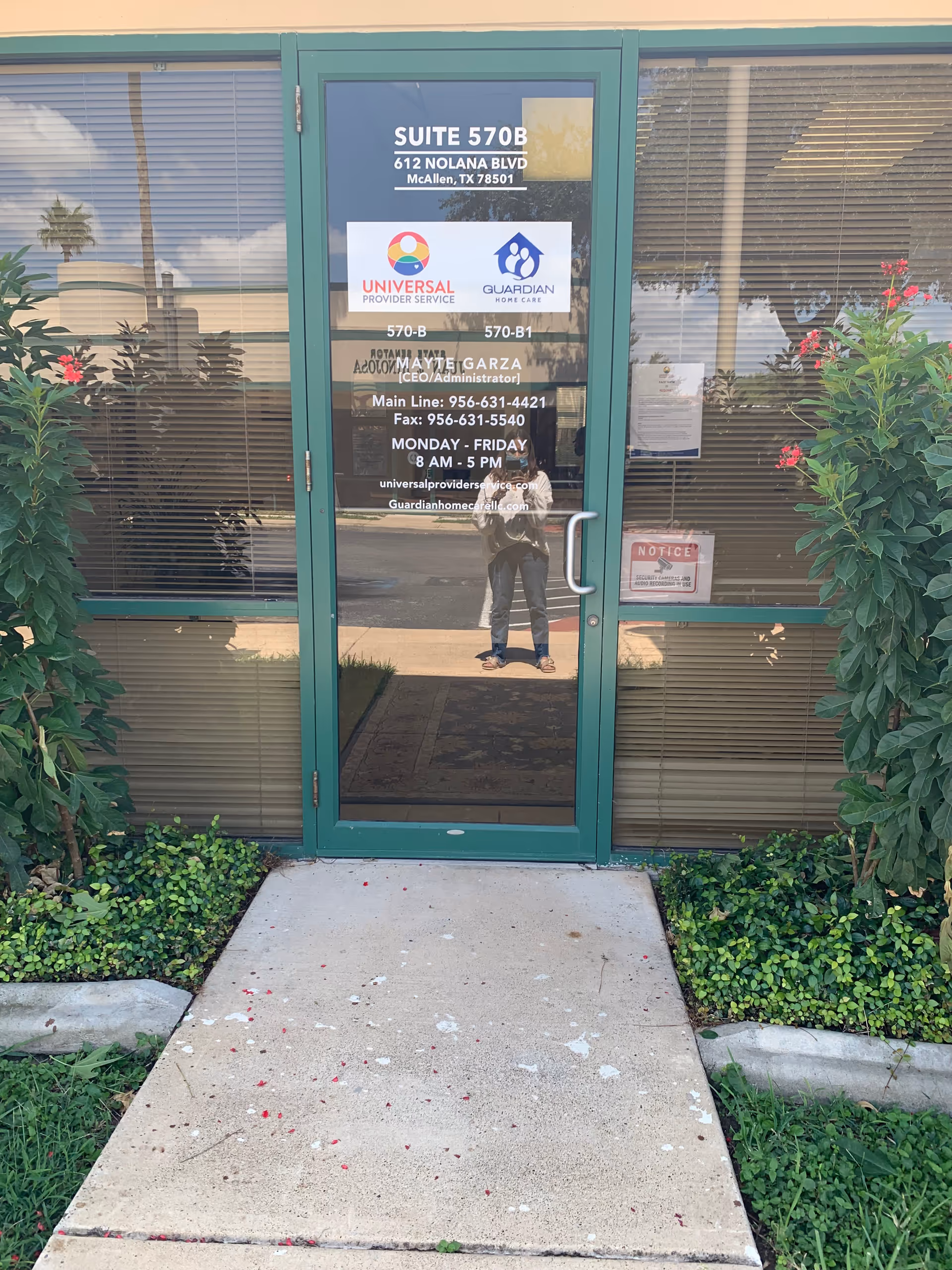 Green framed glass door entrance with Universal Provider Service signage, flanked by shrubs.