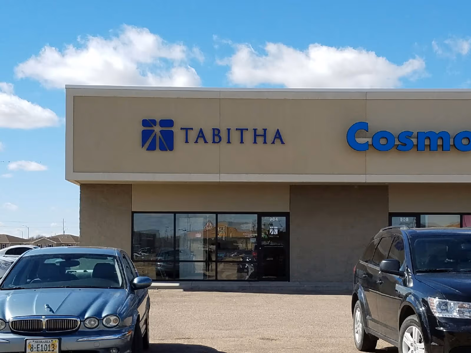 Exterior storefront with Tabitha signage and blue sky above.