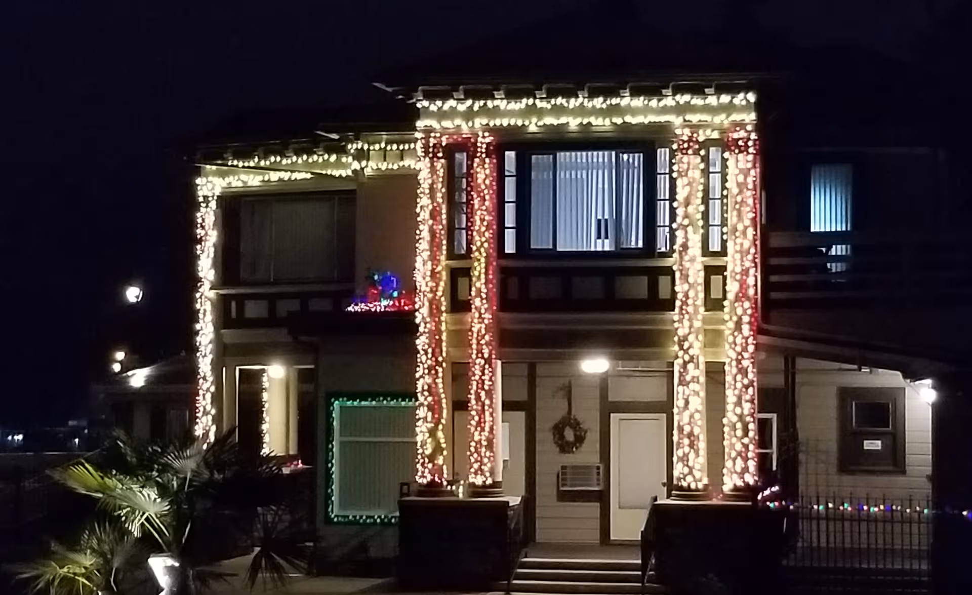 Night exterior of Village Manor of Cascadia with festive lights on front columns.