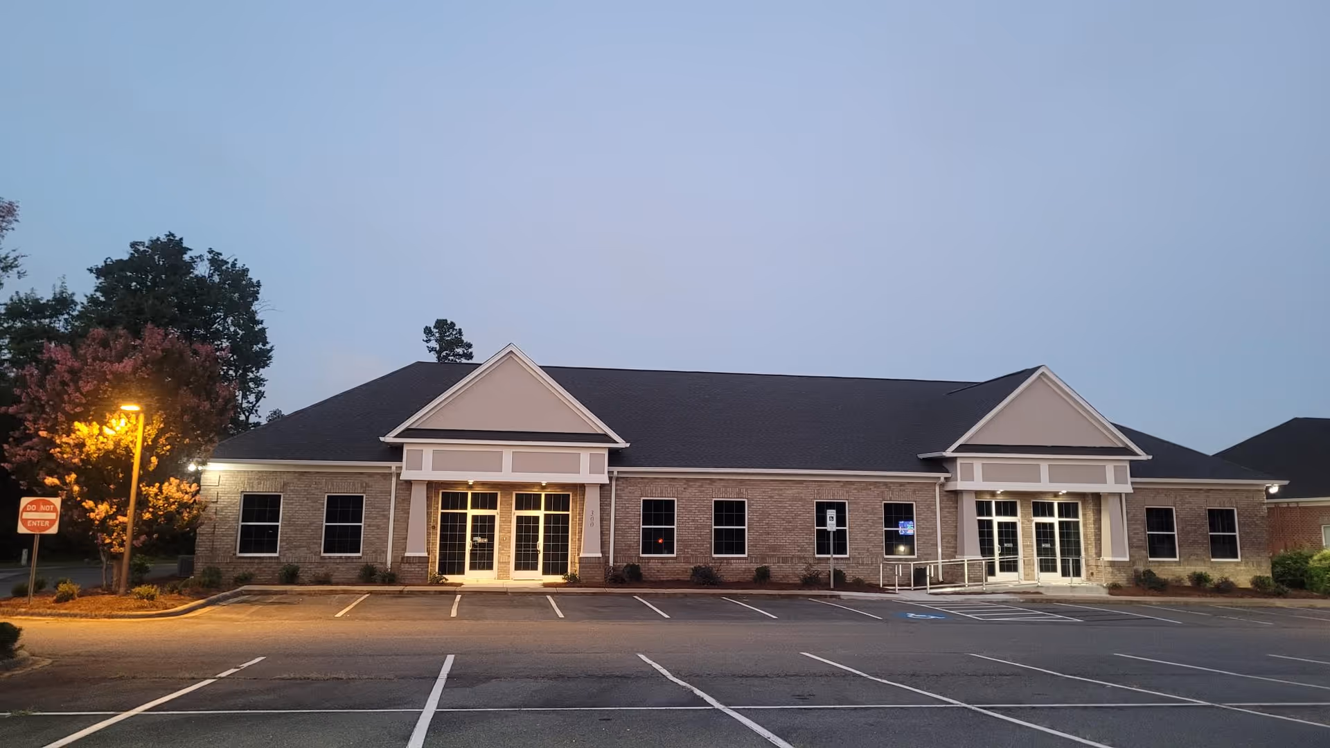 Front view of a single-story brick Helms Home Care facility with two entrances.