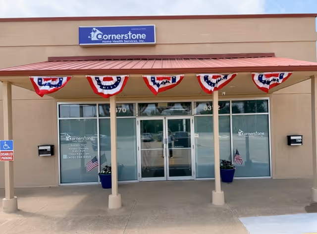 Front view of Cornerstone Home Health Services building with glass doors and patriotic bunting.